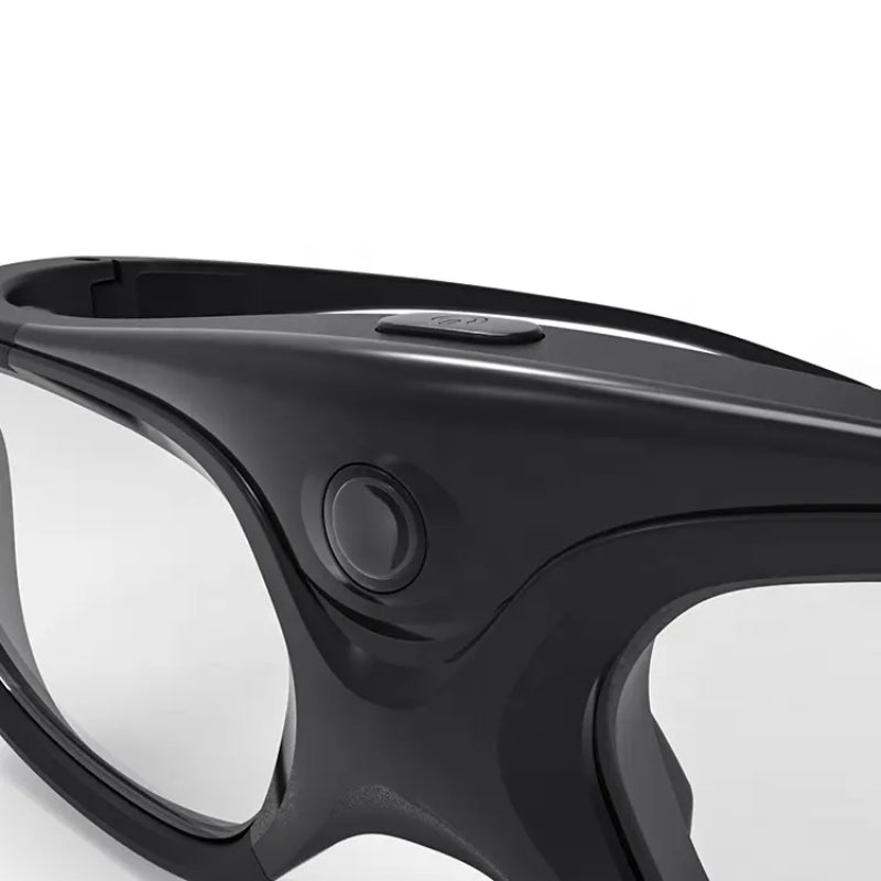 Product photo of sleek black smart glasses with clear lenses a prominent circular side button and a smaller rectangular top button on a white background