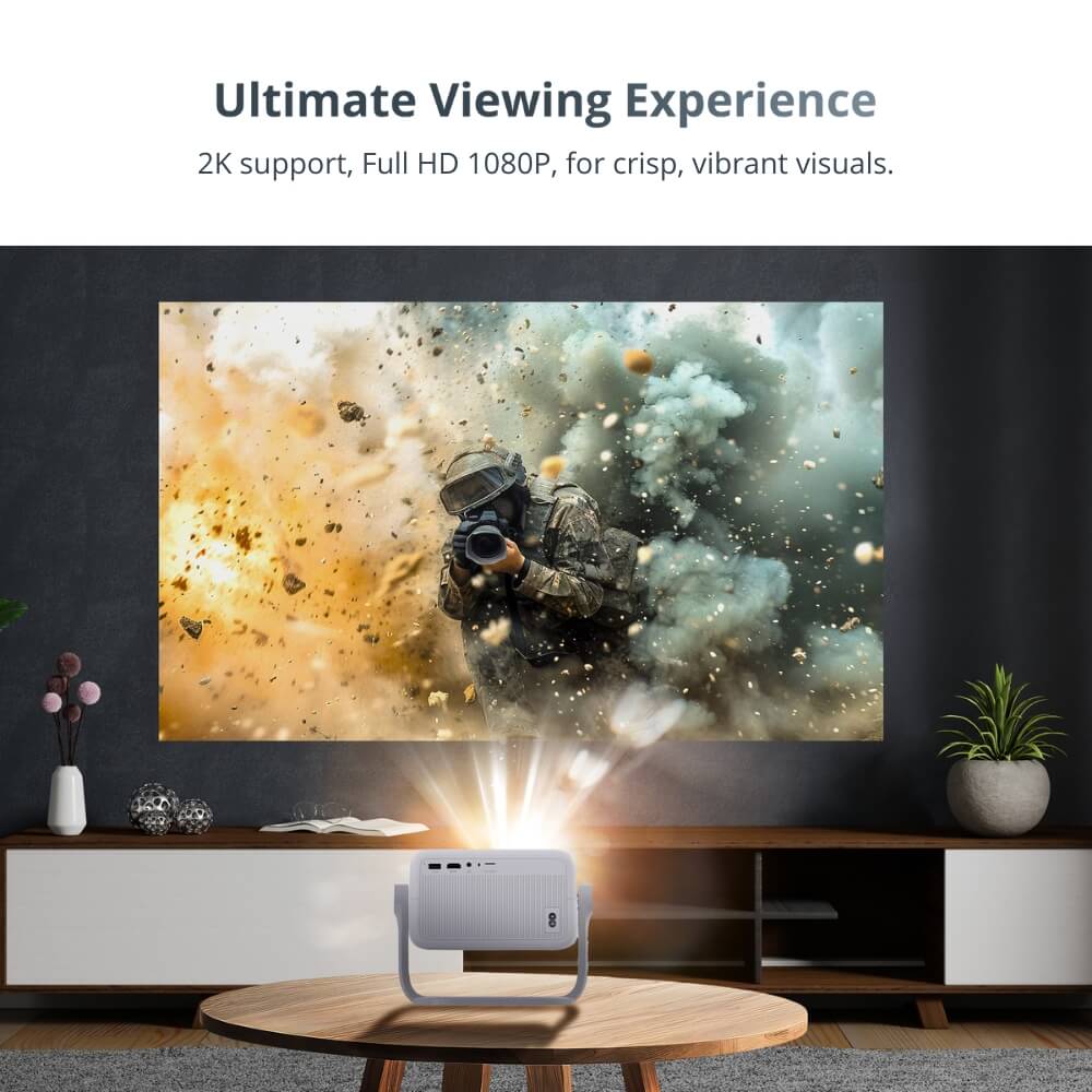 A light grey mini projector with a unique handle stand on a wooden coffee table in a modern living room projects an ultimate viewing experience of a soldier holding a camera amidst a fiery orange explosion and billowing grey smoke
