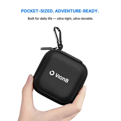 Digital photograph of a light-skinned hand holding a black VionB zippered case featuring a white logo and a silver carabiner clip against a clean white background