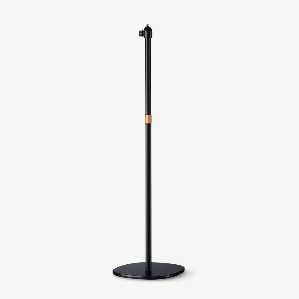 Product photograph of a minimalist matte black floor stand featuring a slim cylindrical pole, a prominent copper accent band, and a sleek oval base with an adjustable top mount