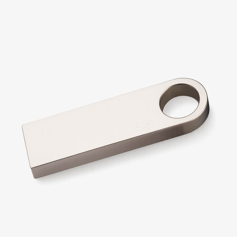 Product photo of a sleek silver metallic 128GB USB flash drive featuring a circular keyring hole at one end
