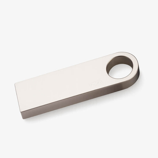 Product photo of a sleek silver metallic 128GB USB flash drive featuring a circular keyring hole at one end