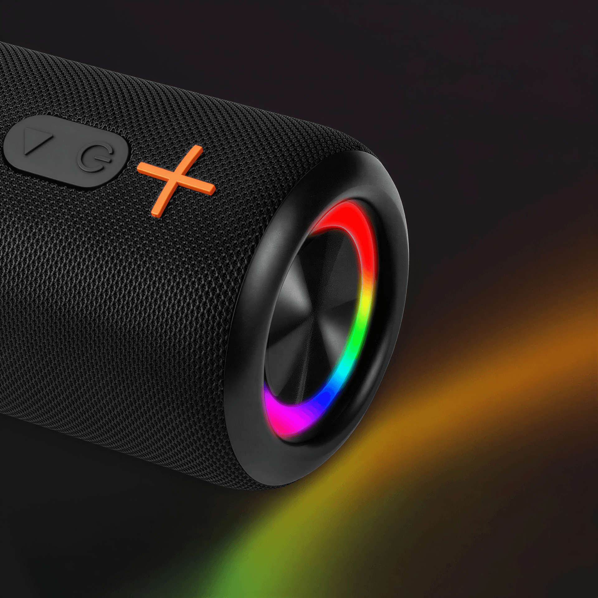 Close-up of a black portable Bluetooth speaker with a woven mesh texture and an orange X logo, featuring a vibrant rainbow LED light ring casting colorful light trails onto a dark background