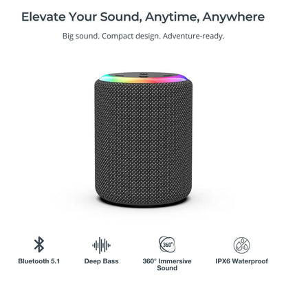 A dark gray portable Bluetooth speaker with a textured mesh fabric exterior and a vibrant rainbow LED light ring on its top surface, set against a clean white background