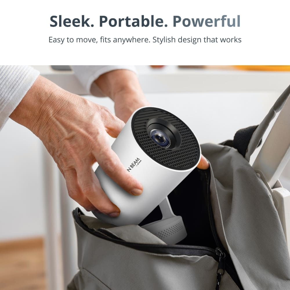 Photograph of a person's hands carefully placing a sleek white cylindrical N BEAM portable projector with a black mesh lens top into a light grey zippered backpack